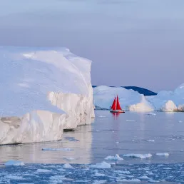 Barca a vela rossa tra gli iceberg