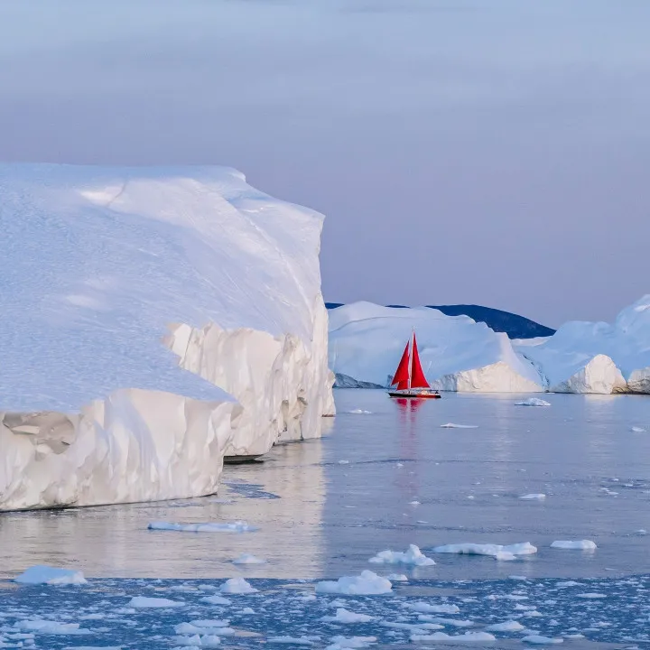 Barca a vela rossa tra gli iceberg