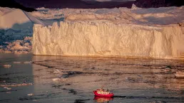 Barca al tramonto tra gli iceberg del fiordo di Ilulissat