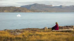 Donna che osserva il mare in Groenlandia